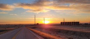 Well pad near a road with sunrise in background