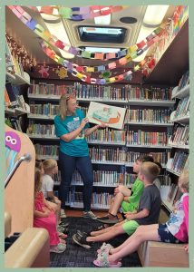 Girl reading a book surrounding by bookshelves