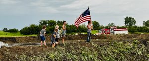 Kids holding an American Flag and playing outside