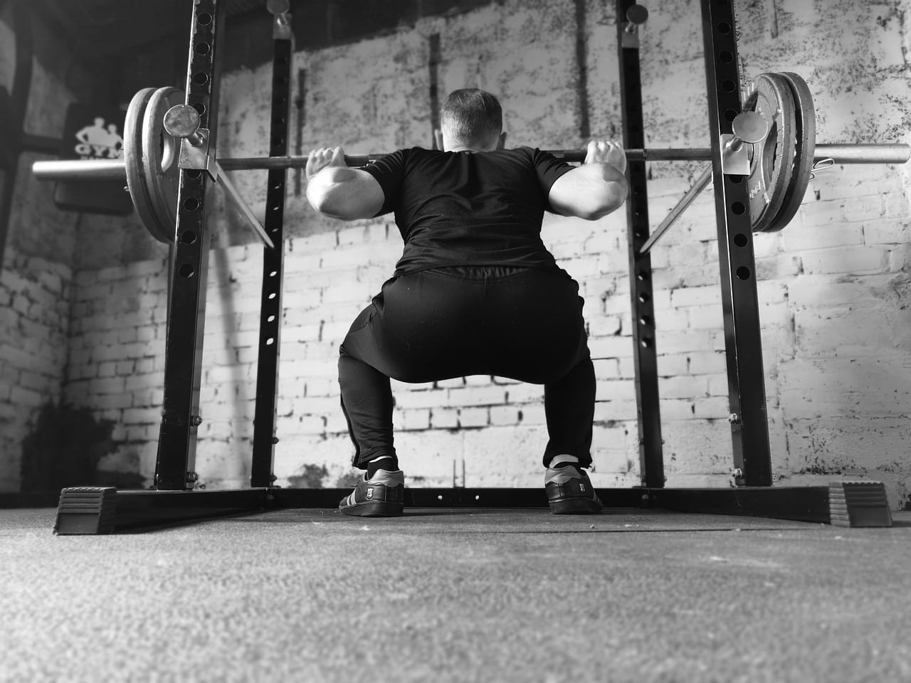 Lifter setting up for a heavy barbell squat in a power rack