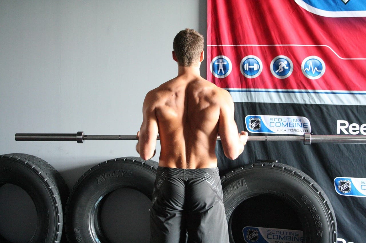 Athlete performing a heavy barbell back squat in a gym rack