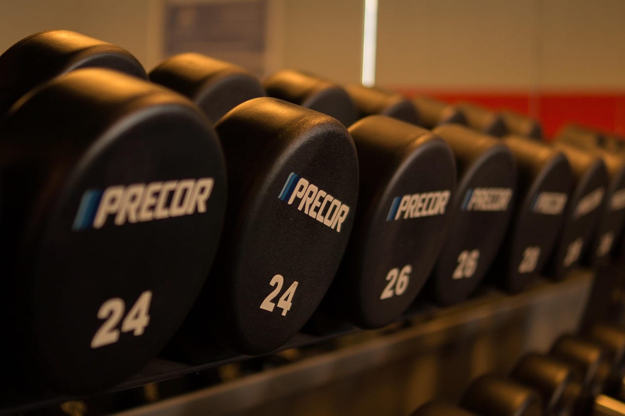 Commercial power rack with barbell and safety pins adjusted
