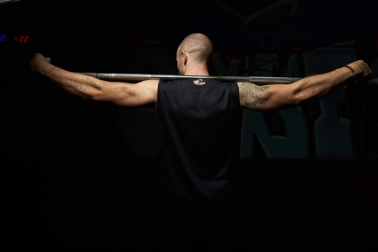 Olympic barbell loaded with plates inside a squat rack