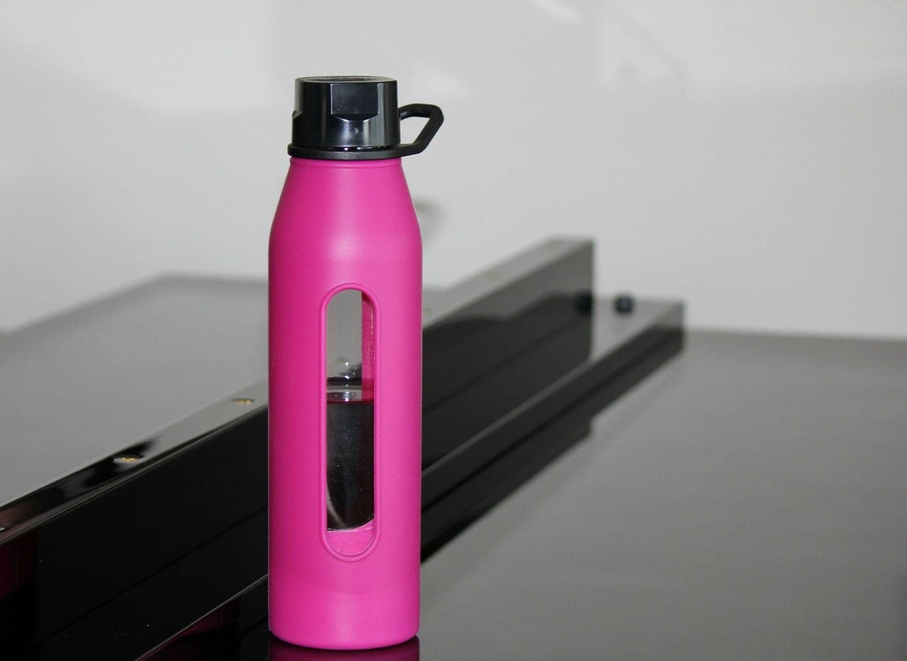 Reusable sports water bottle resting on a training mat
