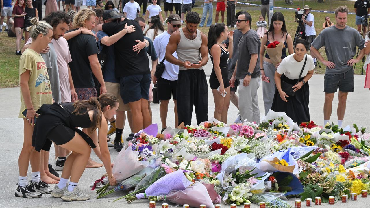 A photo of mourners placing flowers at a makeshift memorial at Bondi.