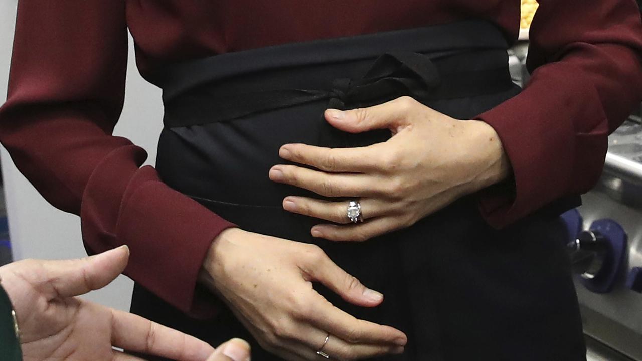 A woman holds her tummy.