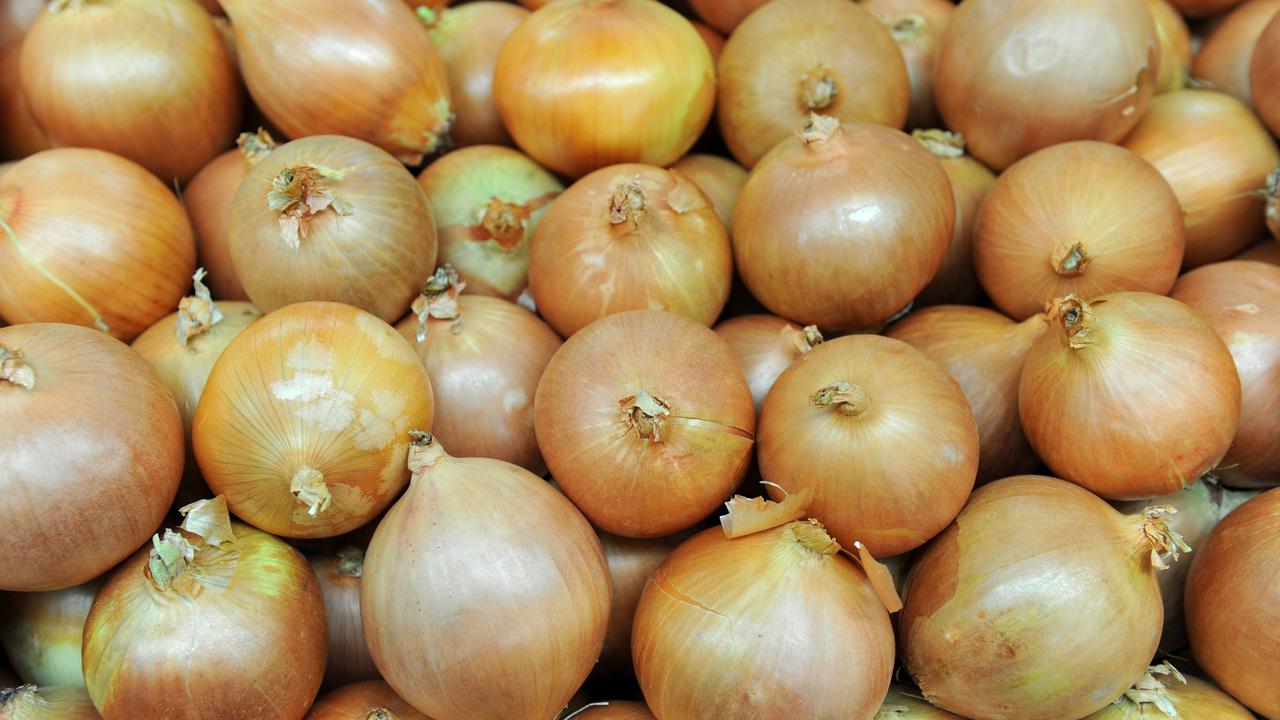 White onions sit on a stall at a store.