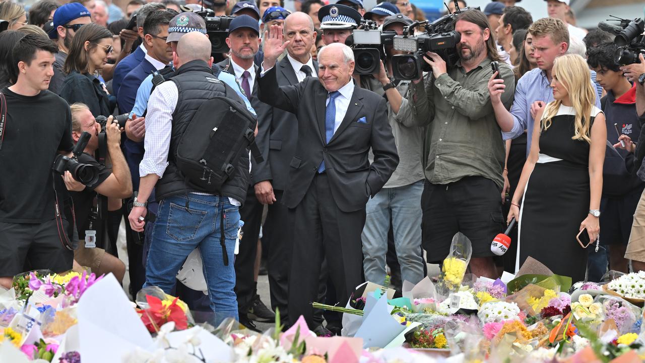 A photo of John Howard placing flowers at a Bondi memorial.