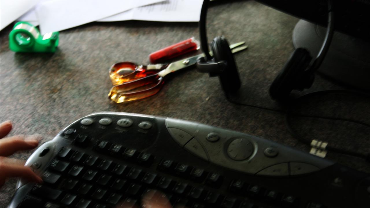 A keyboard and office items on a desk (file image)