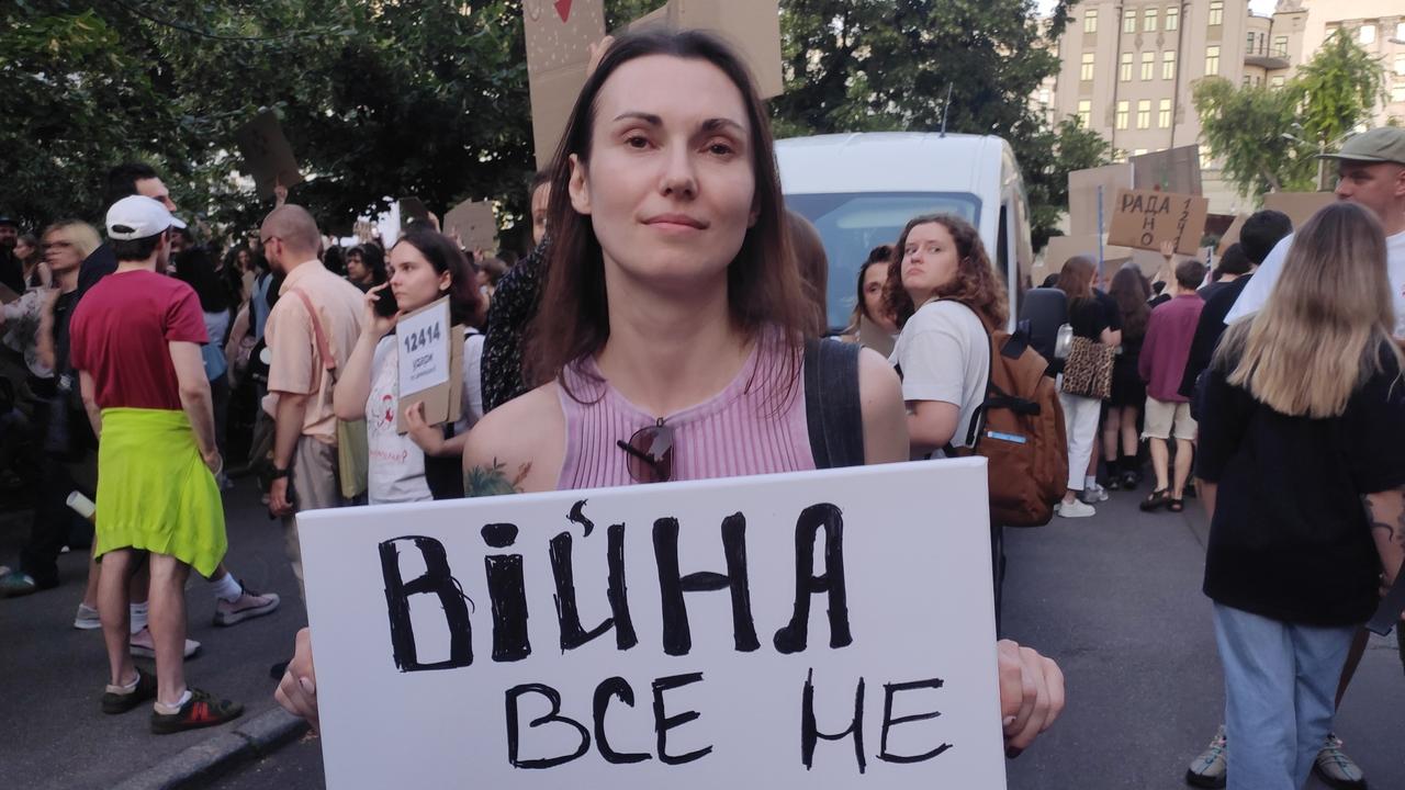 A protester with a sign saying war isn't an excuse for everything.