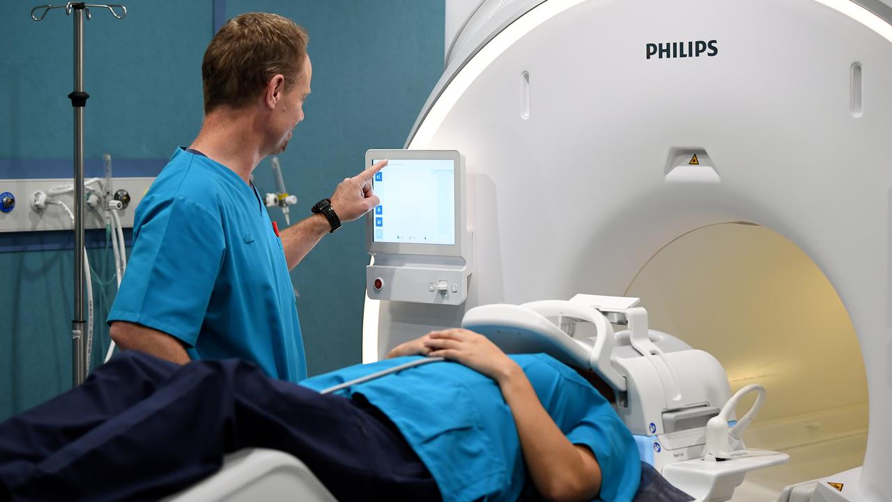 Two operators demonstrate a Ingenia Ambition 1.5T MRI machine