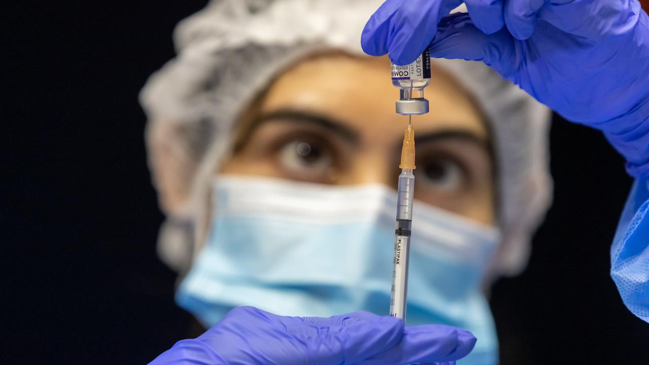 A health care worker fills a syringe with Pfizer vaccine (file image)