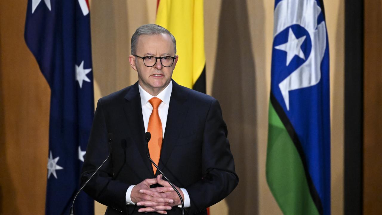 An image of the  Prime Minister in front of the national flag.
