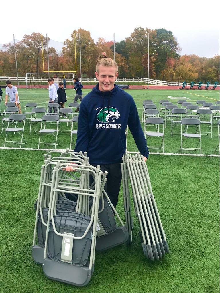 Garret Hunter en de rest van het jongensvoetbalteam hielpen vandaag met het opzetten van stoelen voor de Pep-rally.