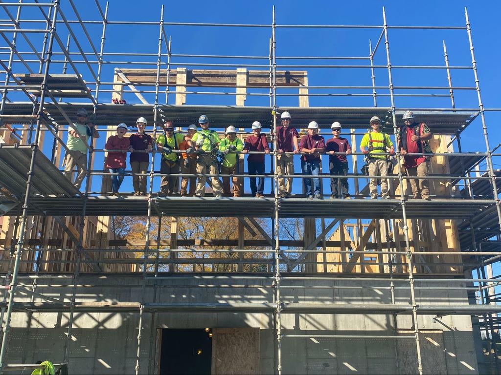 Studenti di falegnameria che lavorano al Larkin Cottage questa settimana insieme a istruttori e apprendisti del sindacato dei carpentieri