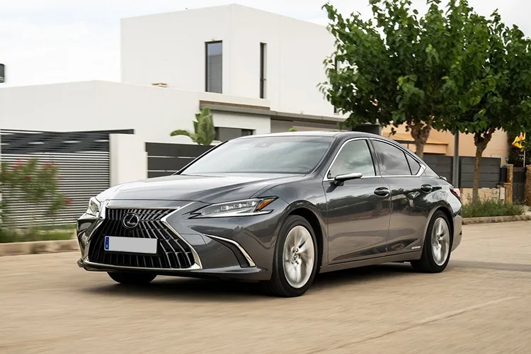 A grey Lexus parked outside a house.