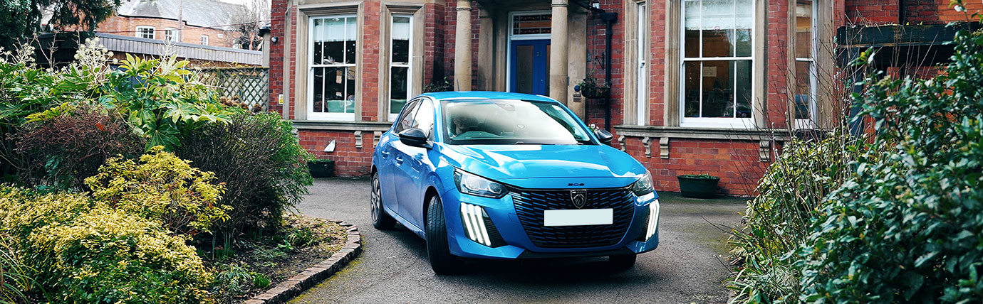 A blue Peugeot parked outside Beaumond House Hospice.