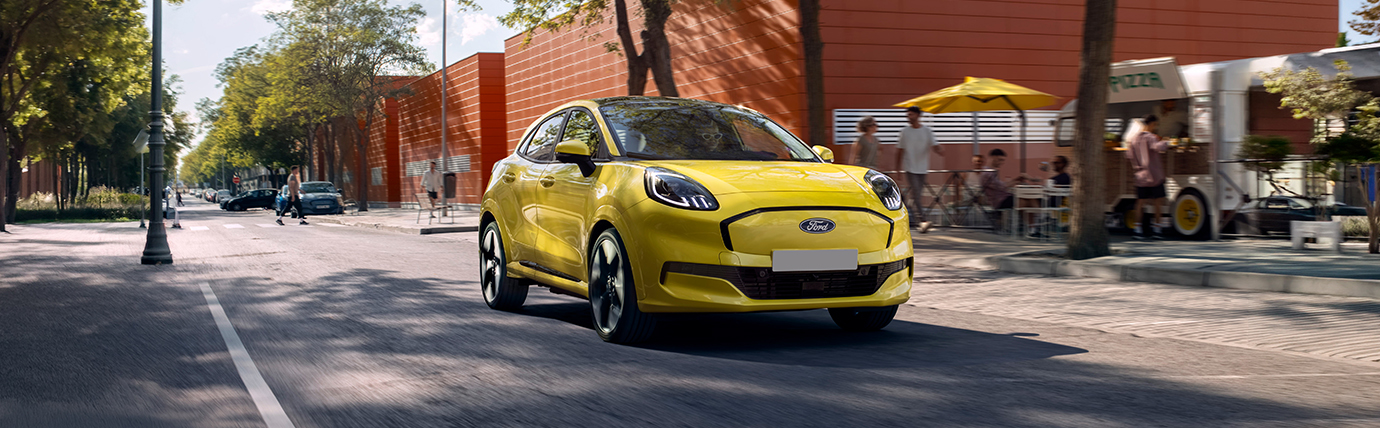 A yellow Ford Puma Gen-E driving along a street.