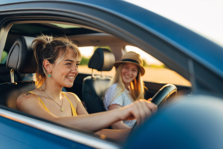 Two people smiling while sat in a car