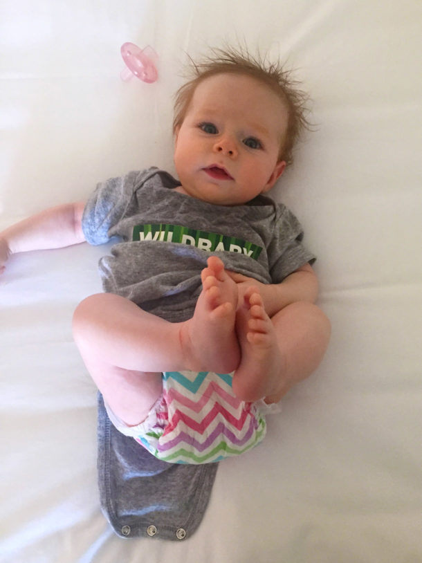 Photo of a baby in a onesie with "Wildbaby" across the front.