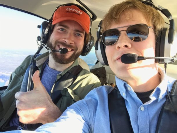 Photo of two people flying together in a small plane