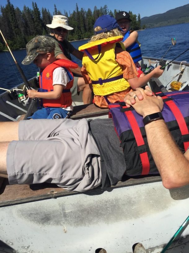 Photo of Chris's family fishing from a small boat while he naps in the back.