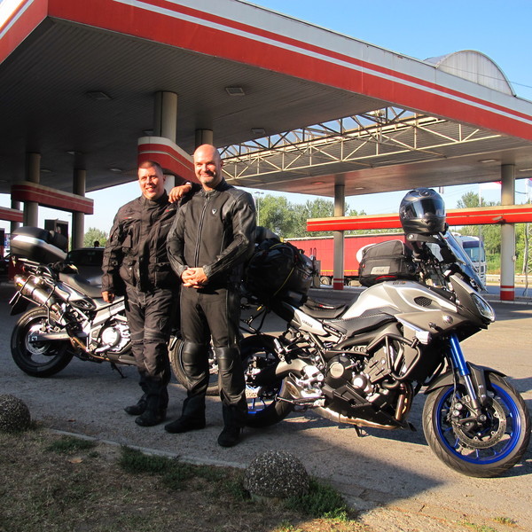 Photo of Milan and his friend standing by their motorcycles.