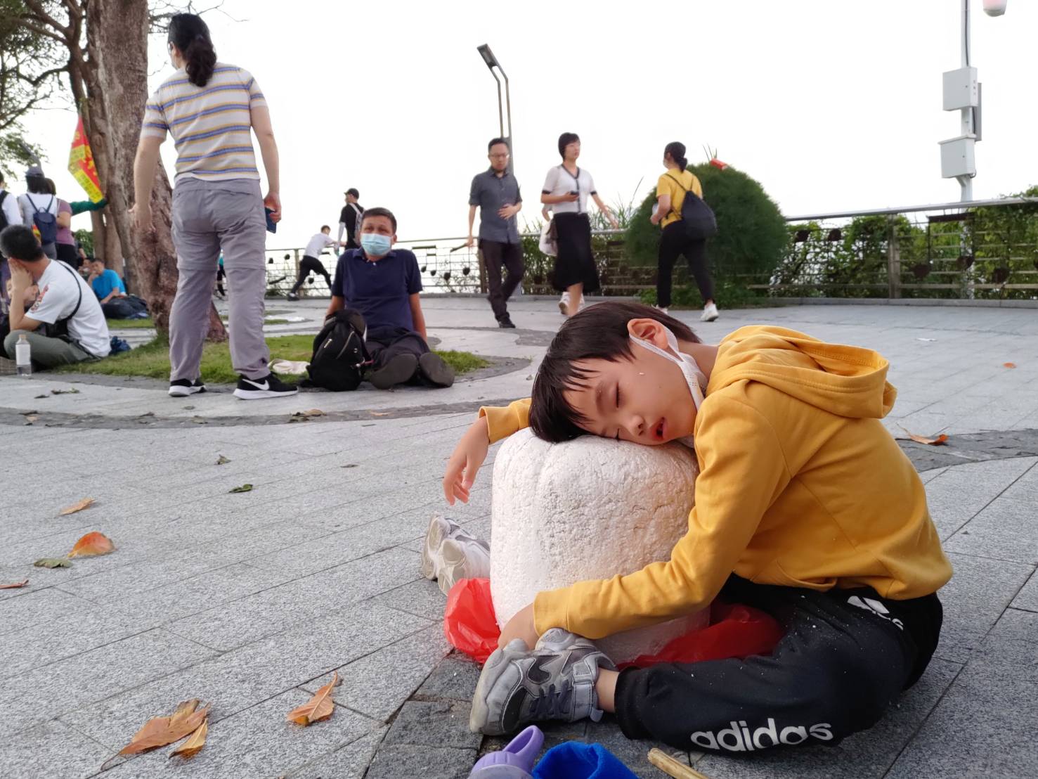 老二等車時累到睡著了，直接躺在撿到的保麗龍上面睡覺