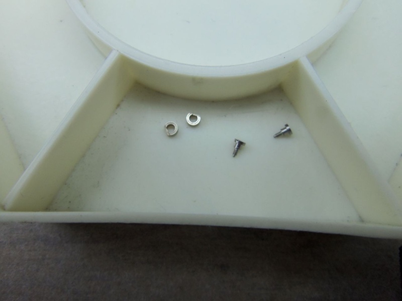 The two screws and holding brackets for chronograph module