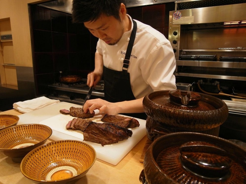 The young chef busy preparing the final dish