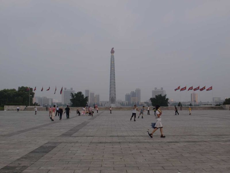 Kim Il Sung Square facing Juche Tower. Notice people rollerblading