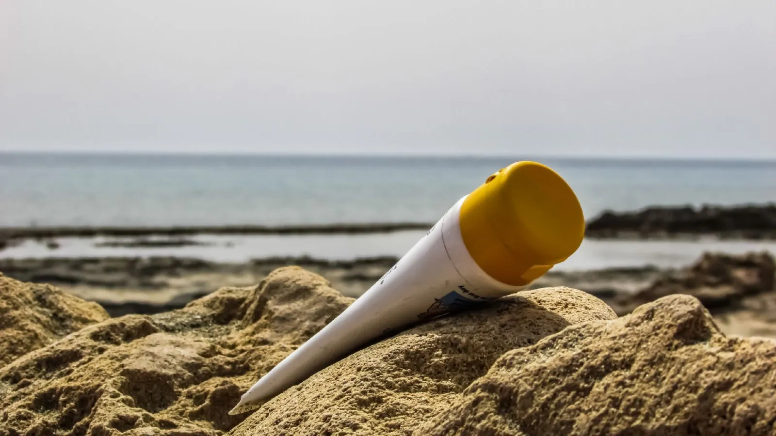 Eine Sonnencreme im Sand am Strand.