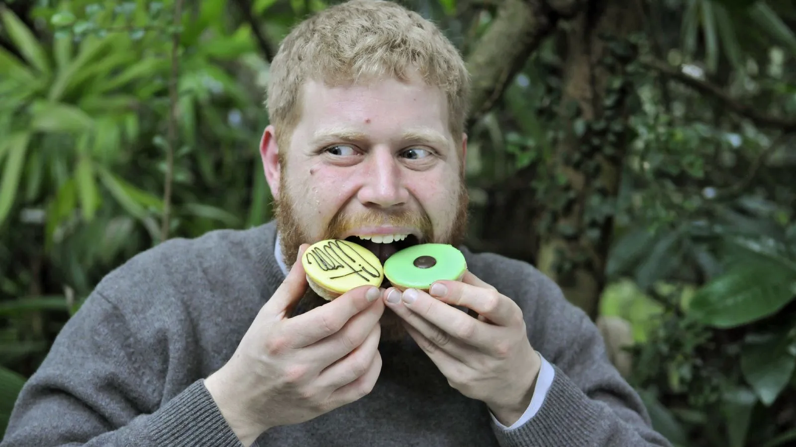Junger Mann isst zwei Pattiseries