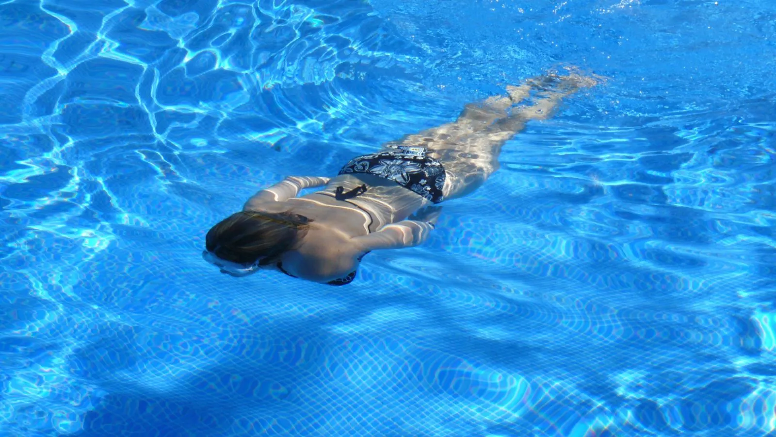 Eine Frau im Badeanzug gleitet durch das Wasser