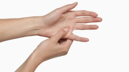 Frau zieht mit der rechten Hand die andere Hand zwischen kleinem Finger und Ringfinger