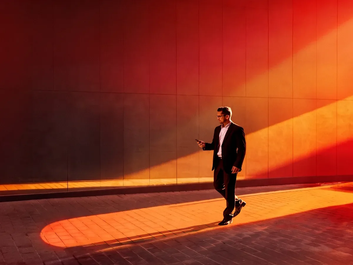 An advisor checking his phone walking down the street