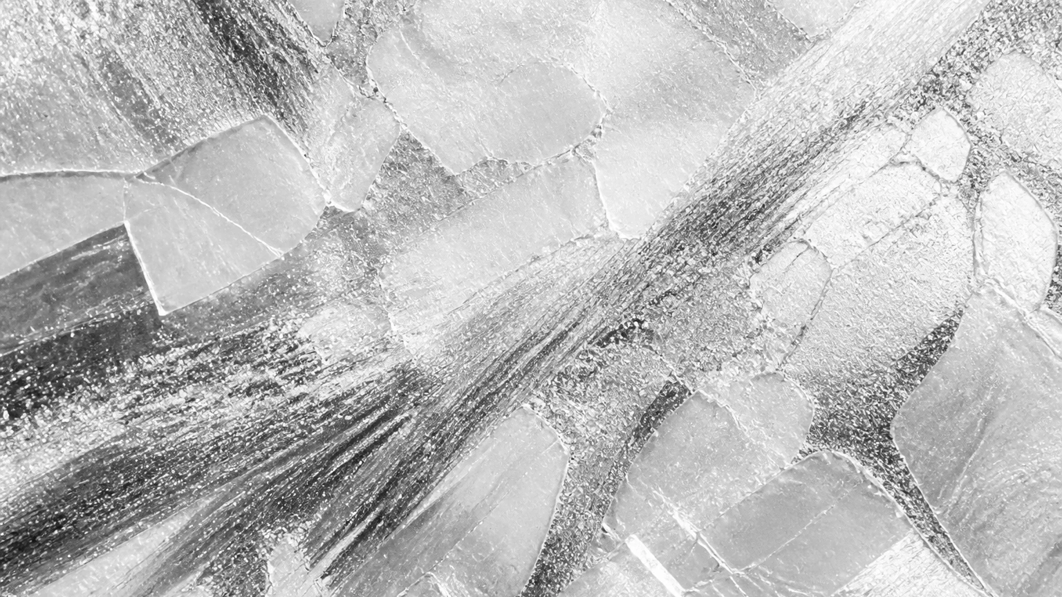 Abstract monochrome crystalline texture with bright mineral planes and graphite shimmer