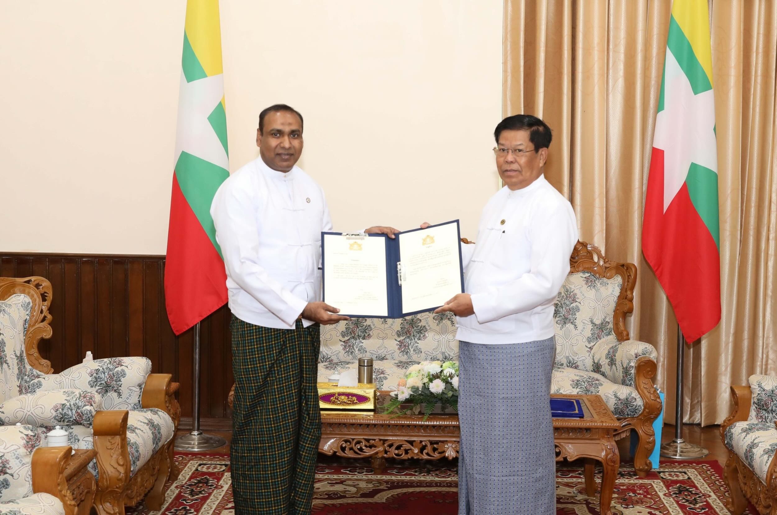 စစ်ကော်မရှင် နိုင်ငံခြားရေးဝန်ကြီး ဦးသိန်းဆွေ (ယာ) က အိုက်စလန်နိုင်ငံ၏ ဂုဏ်ထူးဆောင်ကောင်စစ်ဝန် ခန့်အပ်လွှာကို ဦးကိုကိုလတ် (ဝဲဘက်) အား ပေးနေသည်ကို ဖေဖော်ဝါရီလ ၂၃ ရက်နေ့တွင် ထုတ်ပြန်ထားစဉ် ။ (ဓာတ်ပုံ - MOFA)