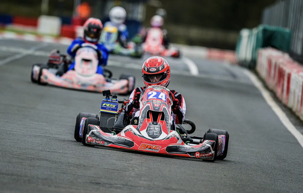 Kart racer number 24 leading the pack with a GoPro mounted on the fairing