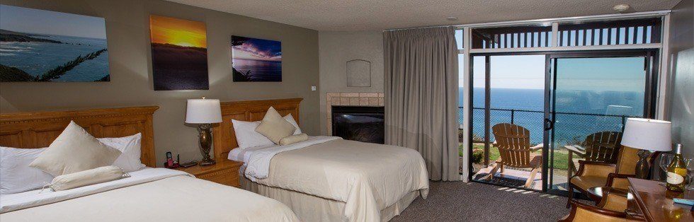 double beds with nearby fireplace overlooking ocean