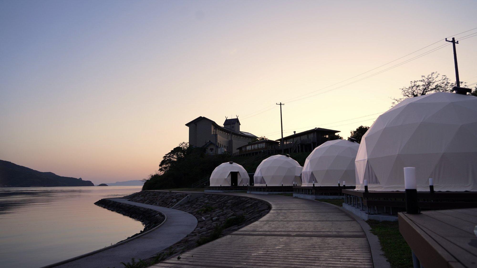 水平線に沈む夕陽を眺める、静かな夕暮れ時。