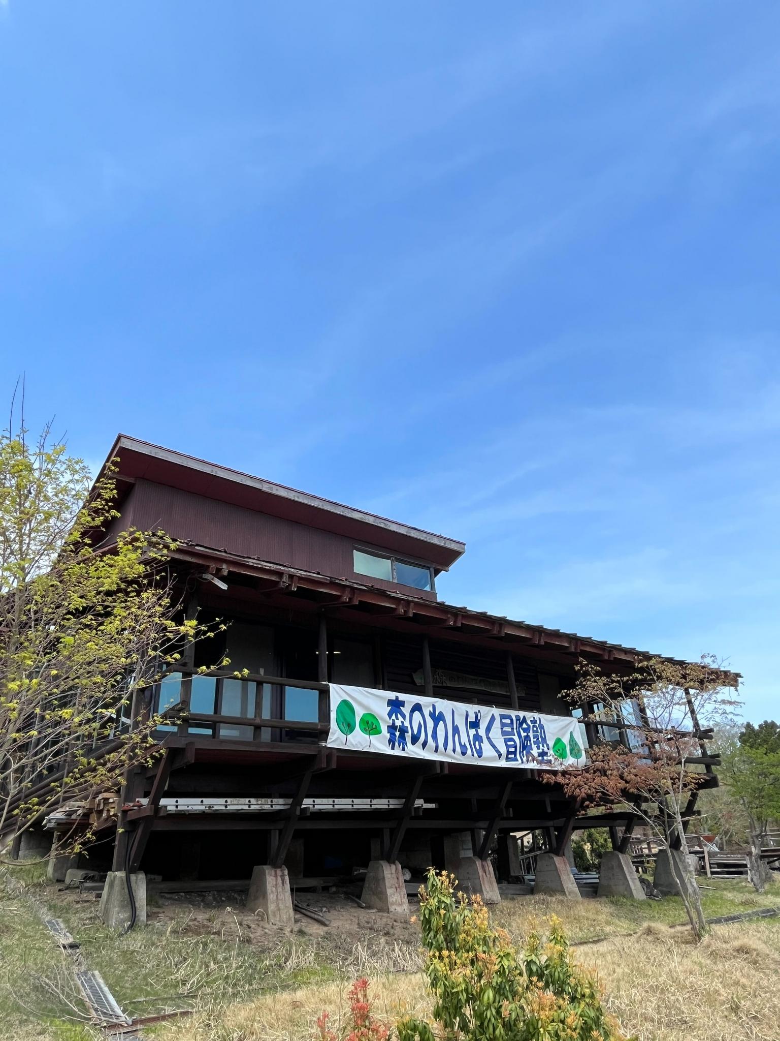 『森のわんぱく冒険塾』と書かれた横断幕のついた、その山荘が峰山わんぱく冒険キャンプ場の管理棟になります✨️館内施設には、ご利用者様に無料で解放している大広間やキッチン、男女トイレとWiFiを完備しております✨️発展途上のため、飲水については現在整備中となりますため、ご利用者様には飲料水のご用意をお願いしております。