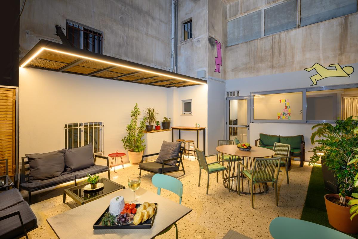 Cozy shared balcony at Psiri Vibes Hotel with seating arrangements and decorative plants.