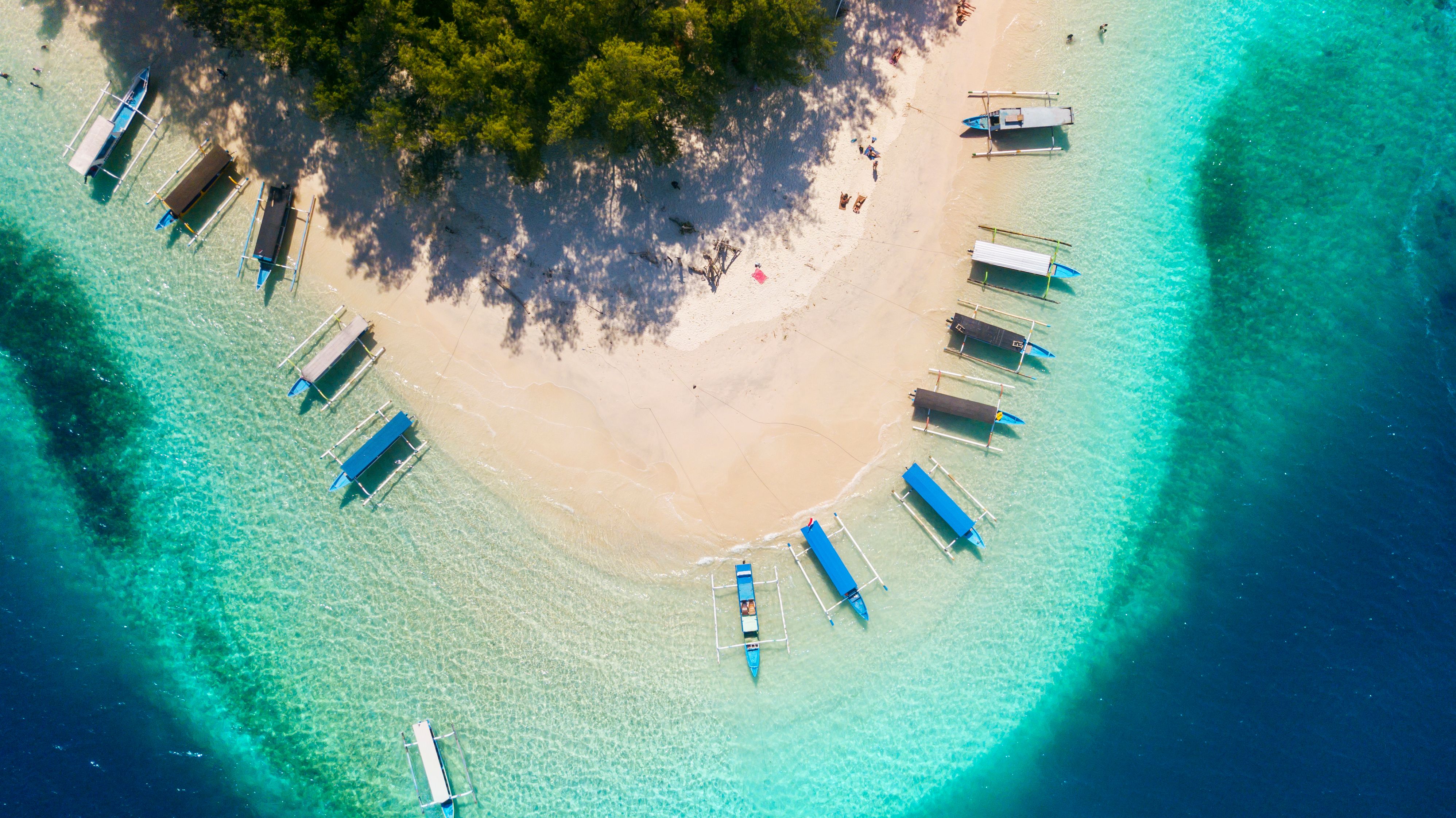 view of Gili Nanggu island with white sand and traditional boats in Bali, Indonesia