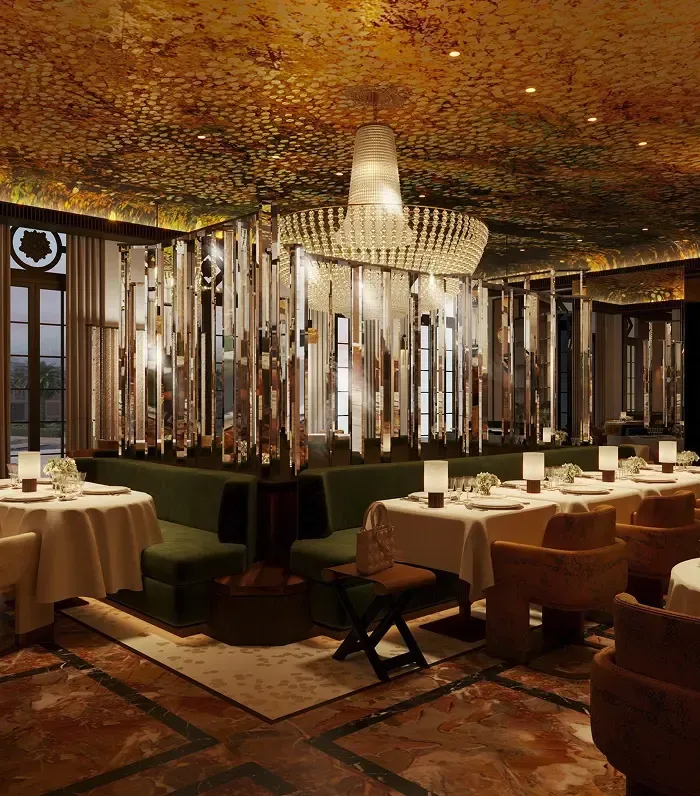 An opulent restaurant interior features a grand chandelier, velvet seating, and elegantly set tables.