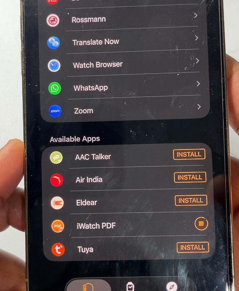 The same list a moment later: iWatch PDF shows a progress circle instead of Install while it downloads to the watch