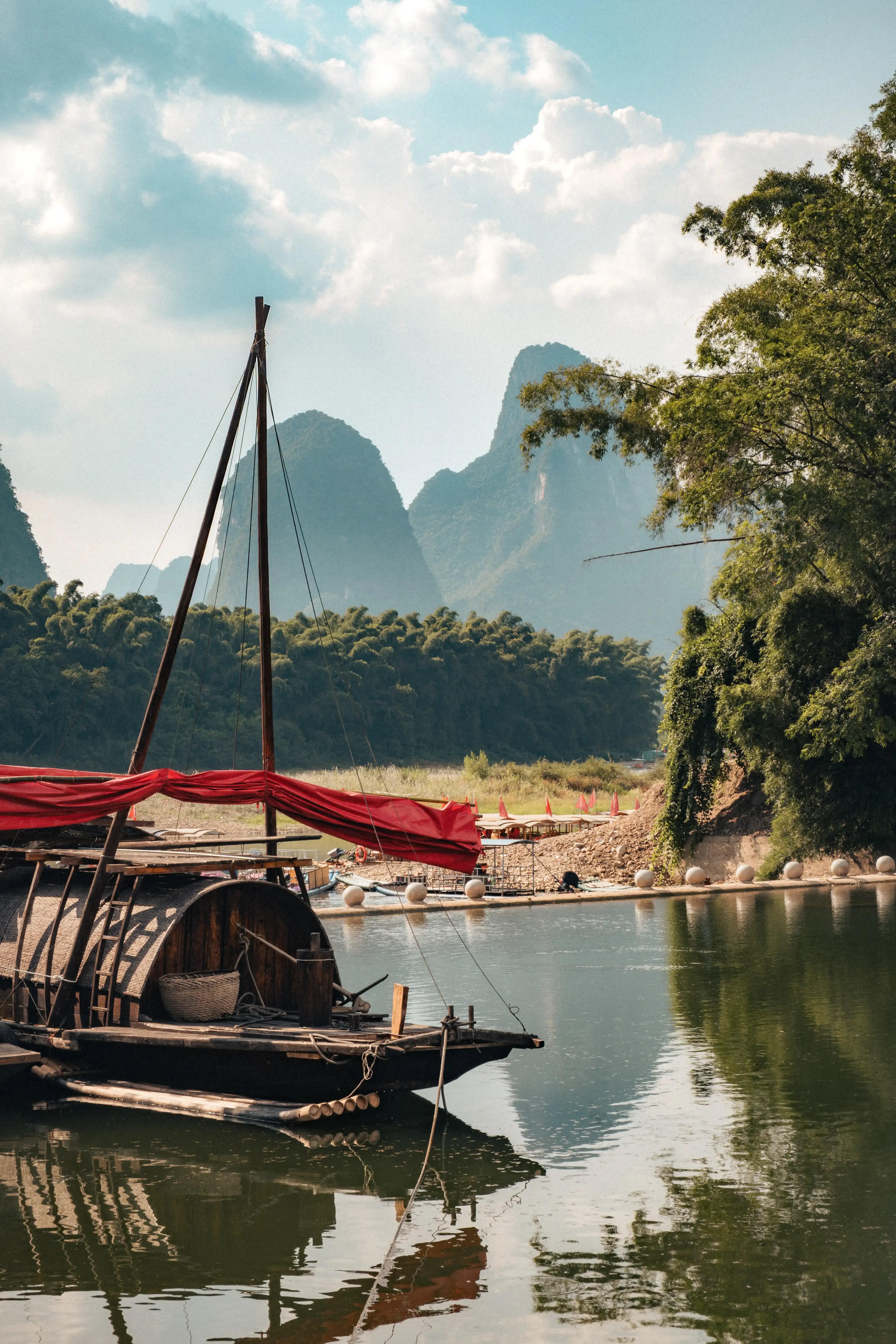 Bateau en bois avec voile rouge sur la rivière Li, eau vert émeraude, Yangshuo, Chine