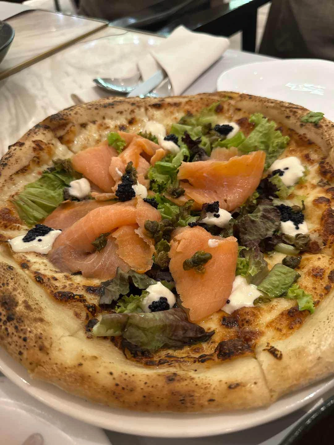Pizza with cured salmon, cream cheese, and caviar
