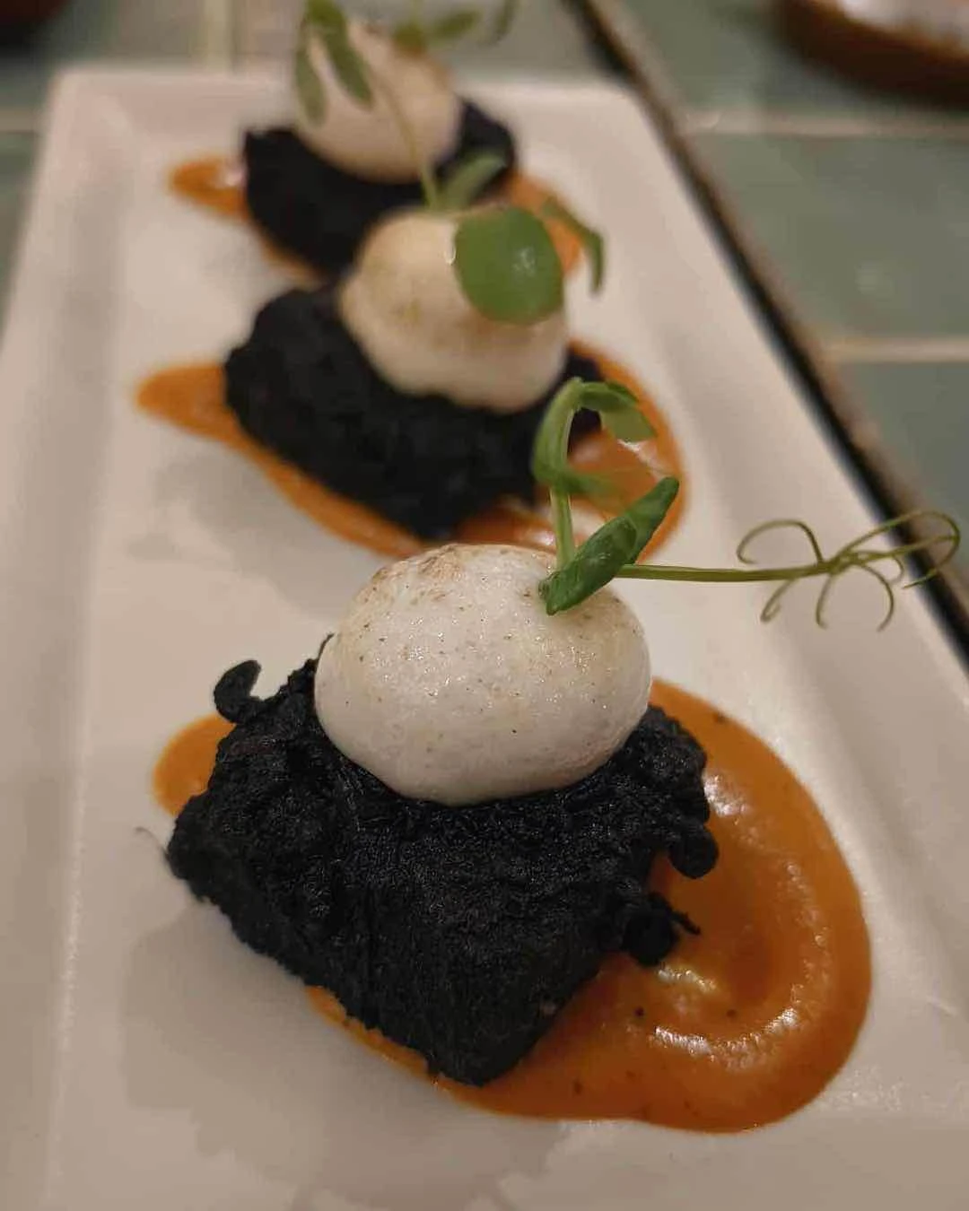 Squid ink tempura barramundi with piquillo sauce