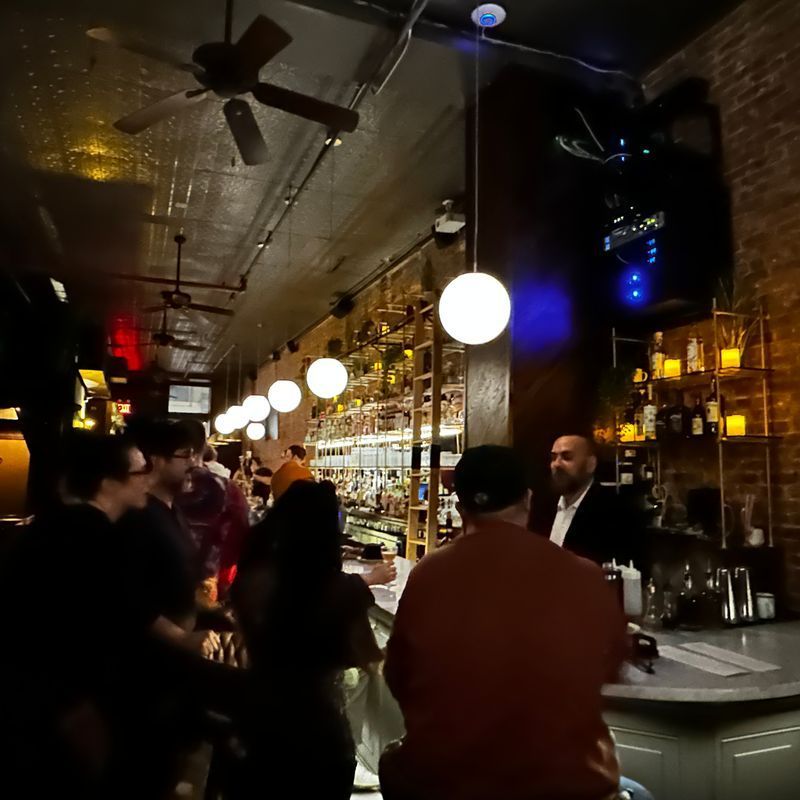 The marble bar and spirits library inside Little More, a cocktail bar and restaurant in Tribeca